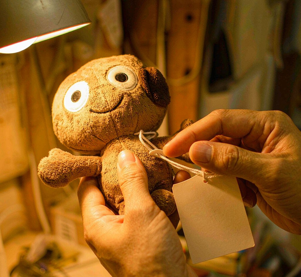 A collector examining plush toy hang tags and stitching detail on a display shelf