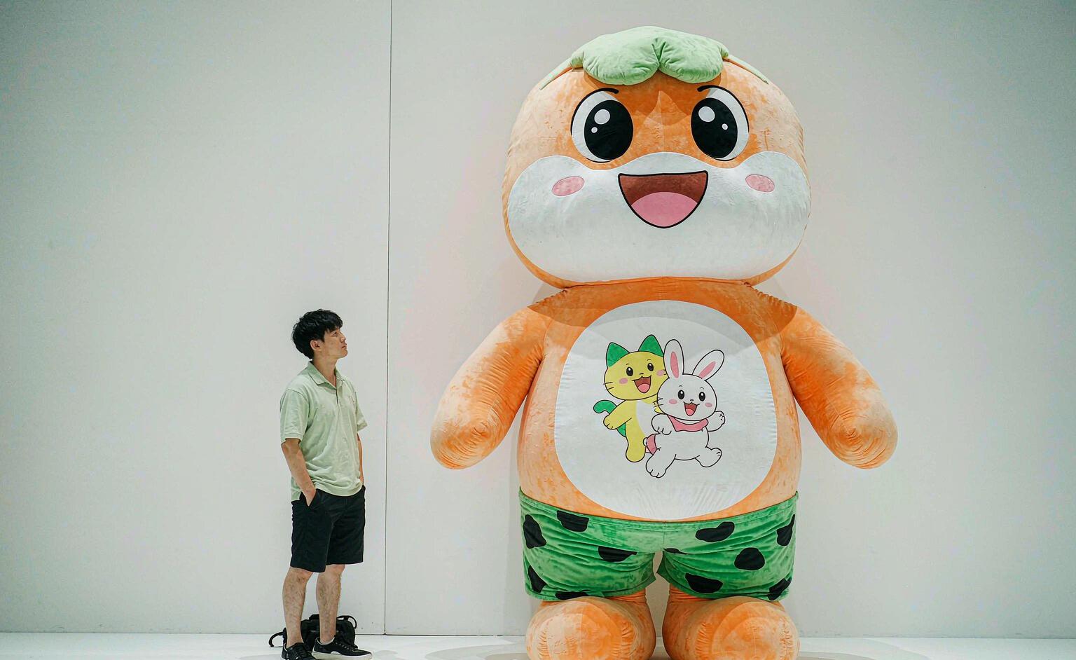 A size comparison chart showing giant plush toys next to average human heights