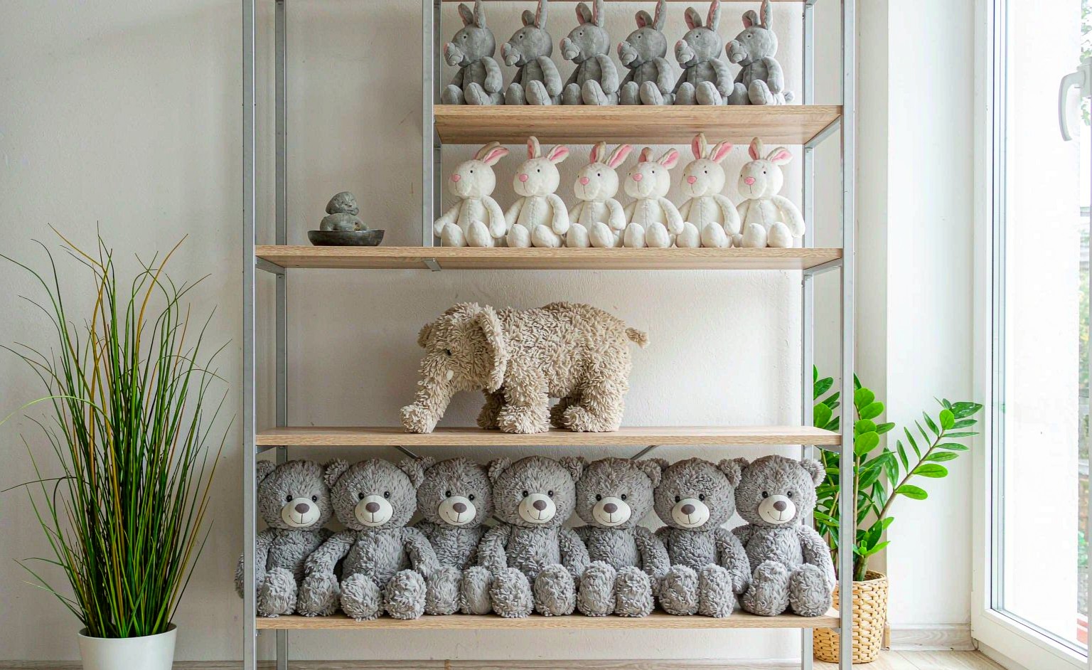 Plush toys arranged on open shelving as a display in a bright living room