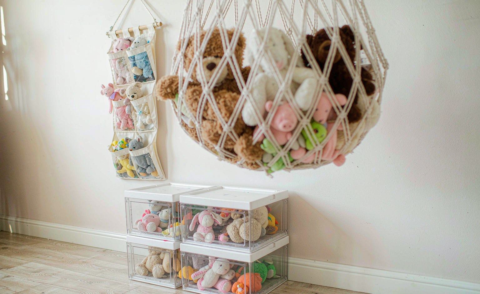 Different plush toy storage methods: hanging organiser, lidded clear bins and a corner net